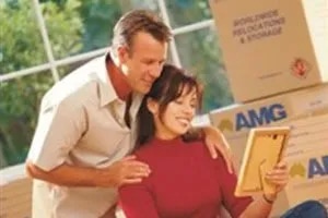 Happy couple looking at picture while unpacking boxes