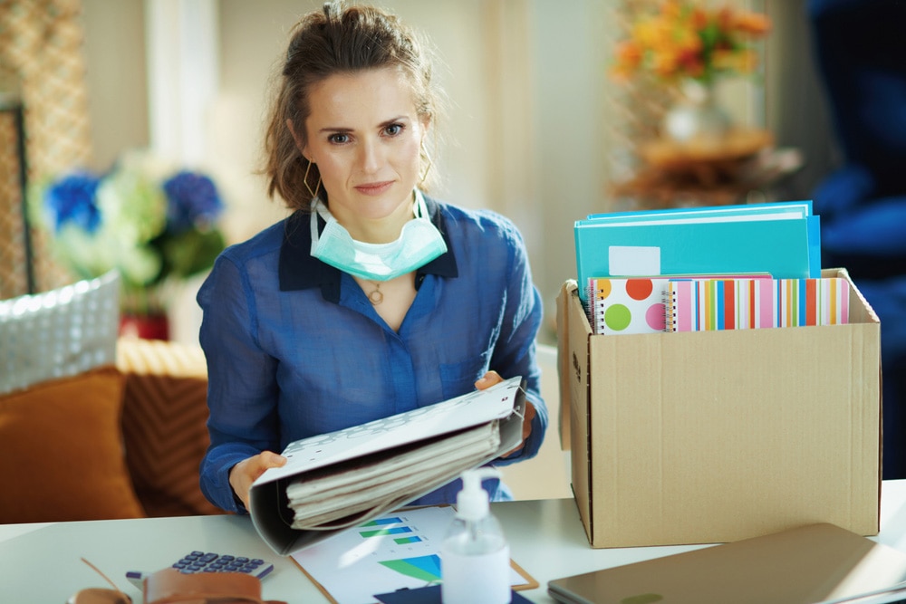 Woman with mask packing up folders