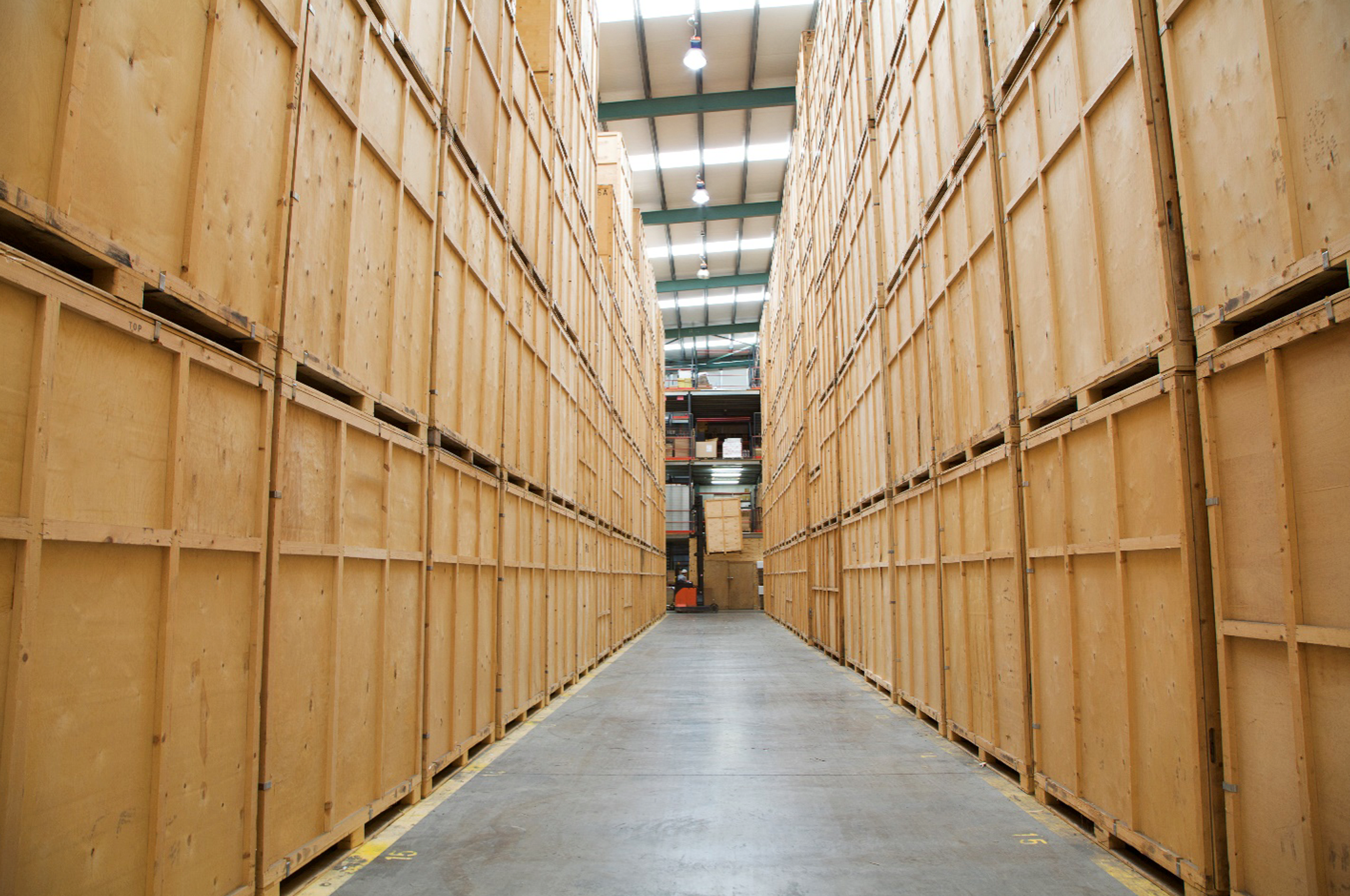 An aisle of wooden shipping containers in a storage facility